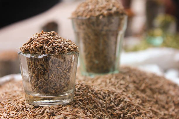 close up view of glass filled with cumin seeds, jeera