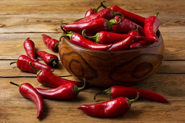 red hot chilli pepper in wooden bowl. spicy food concept.